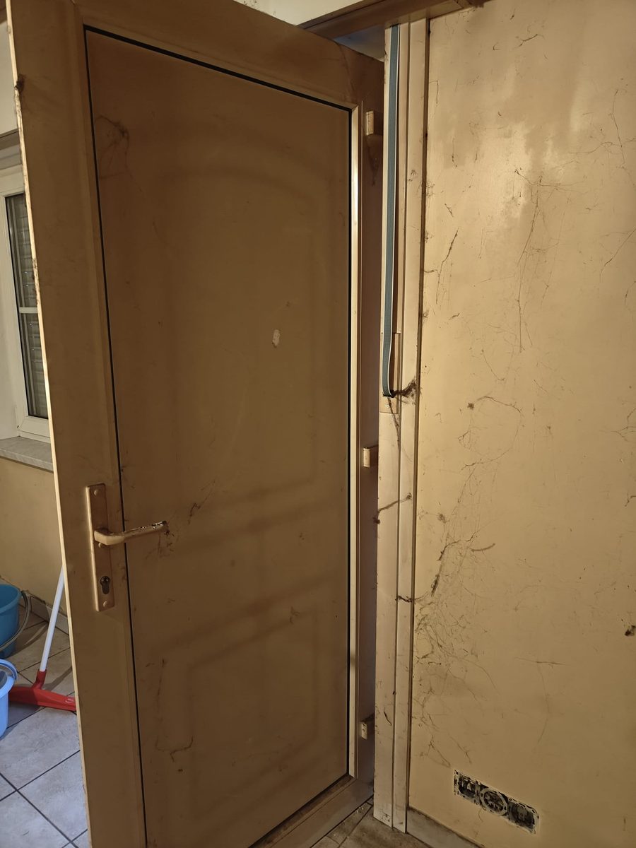 Deur en muur met spinnenwebben en vuilstrepen, voor de schoonmaak